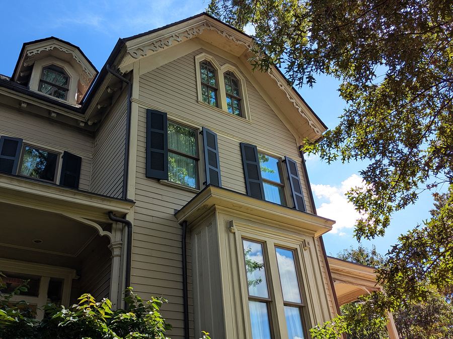 Detail of the upper facade, showing the bay window, shutters and decorative eaves