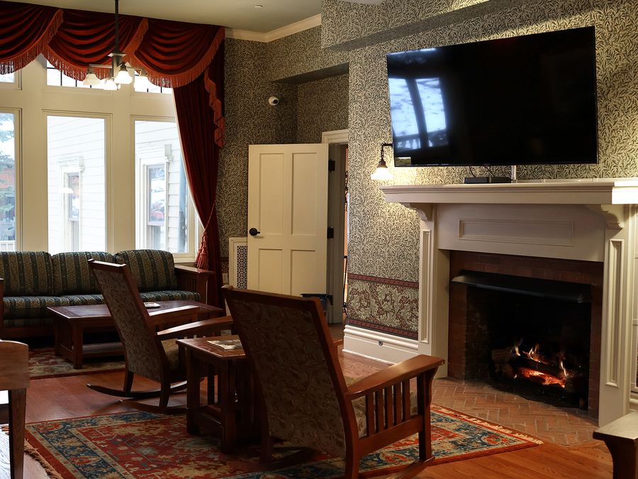 Sitting room with a brick fireplace, mantel and tall windows